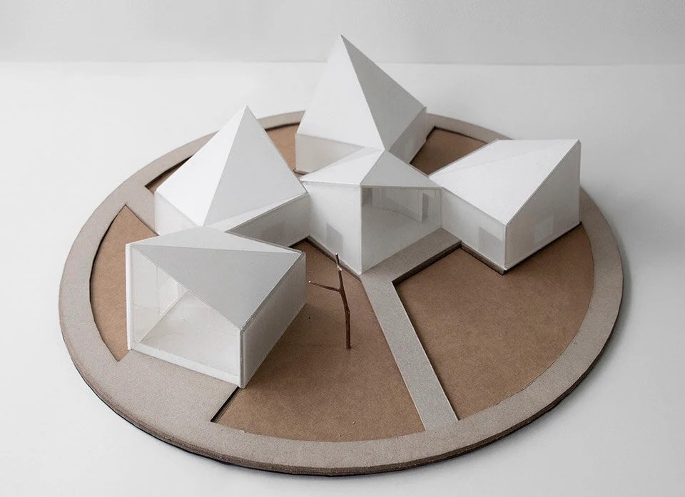 کتابخانه روستایی آتلیه Xi مجموعه ای از بلوک های زاویه دار در یک زمین پوشیده از گل است