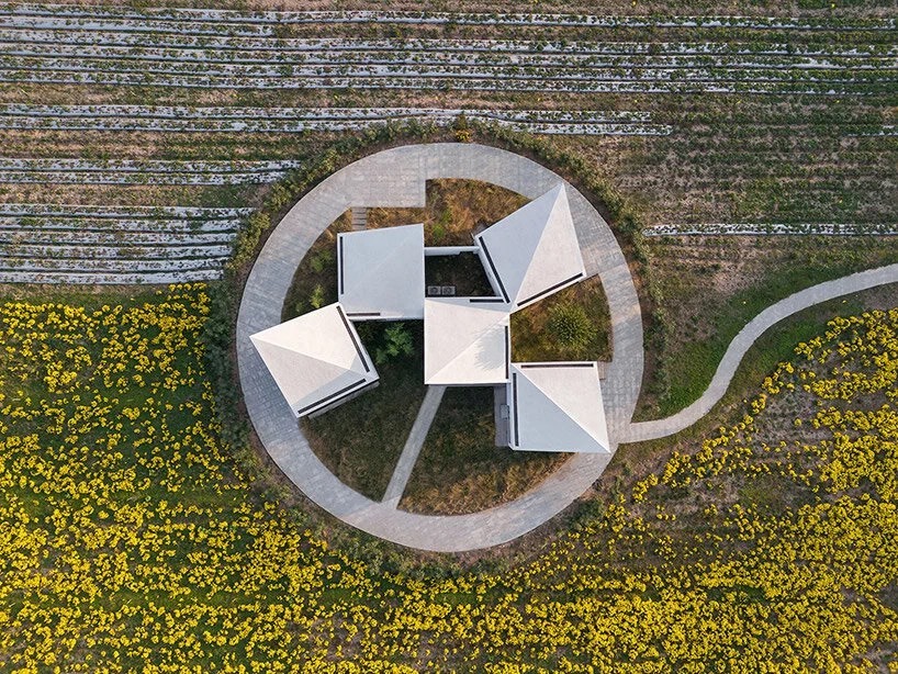 کتابخانه روستایی آتلیه Xi مجموعه ای از بلوک های زاویه دار در یک زمین پوشیده از گل است